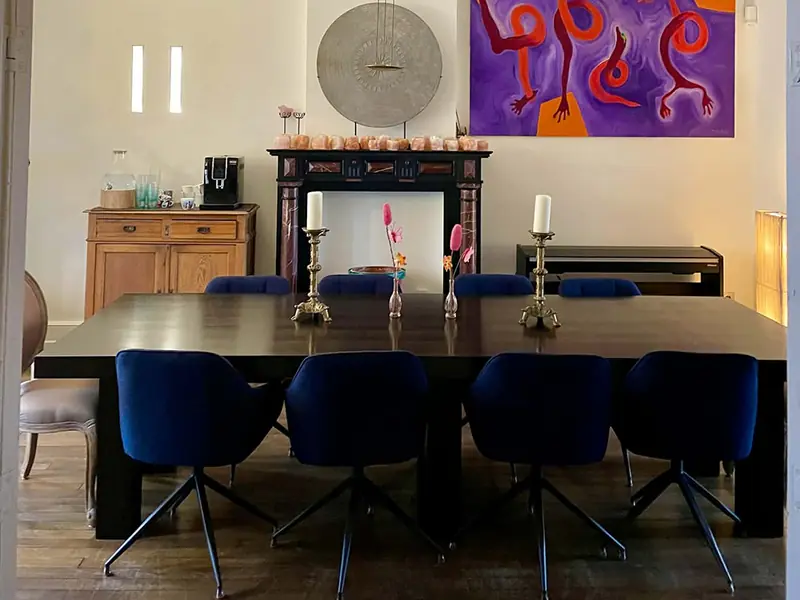 Eetkamer met lange tafel en kunst
