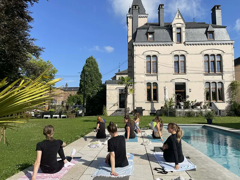 Gasten doen yoga in de tuin van Villa O