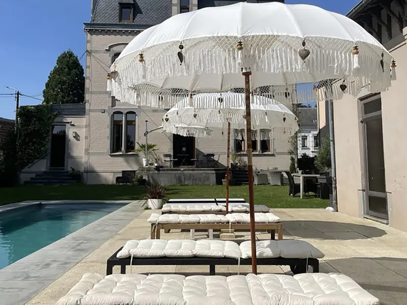 Terras met parasols en ligbedden bij het zwembad